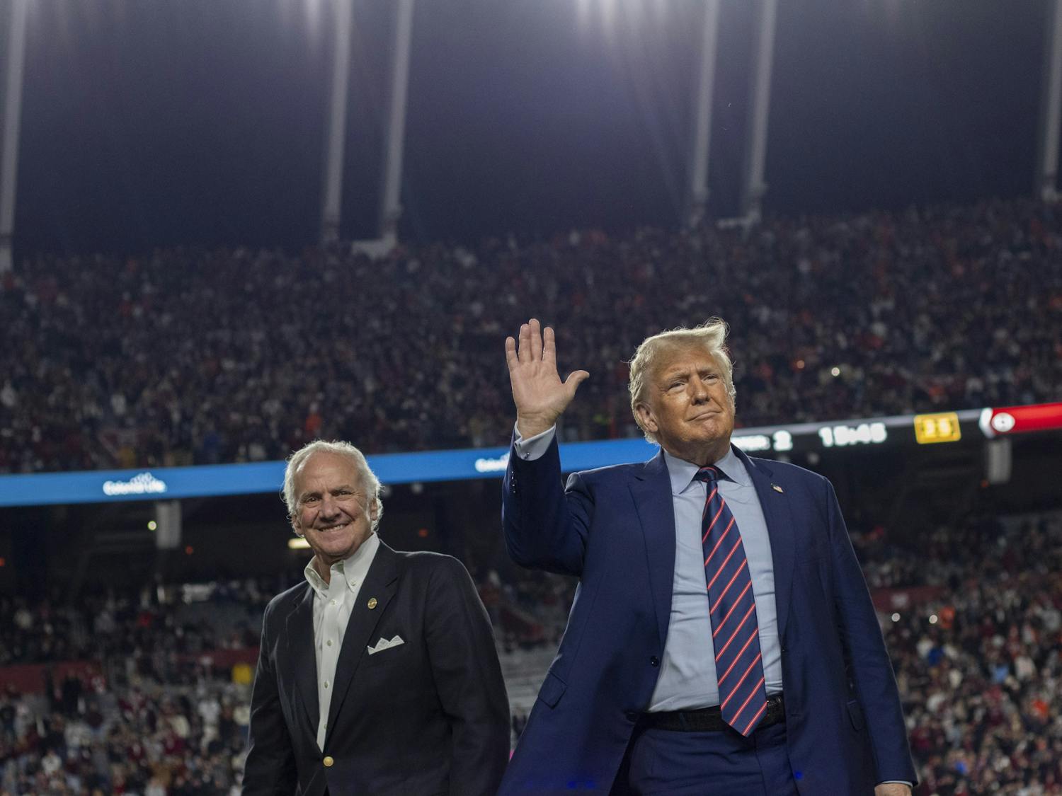Donald Trump, the 45th president of the United States, waves with South Carolina Gov. Henry McMaster at Williams-Brice Stadium on Nov. 25, 2023. His appearance drew a mixture of praises and boos from the crowd. 