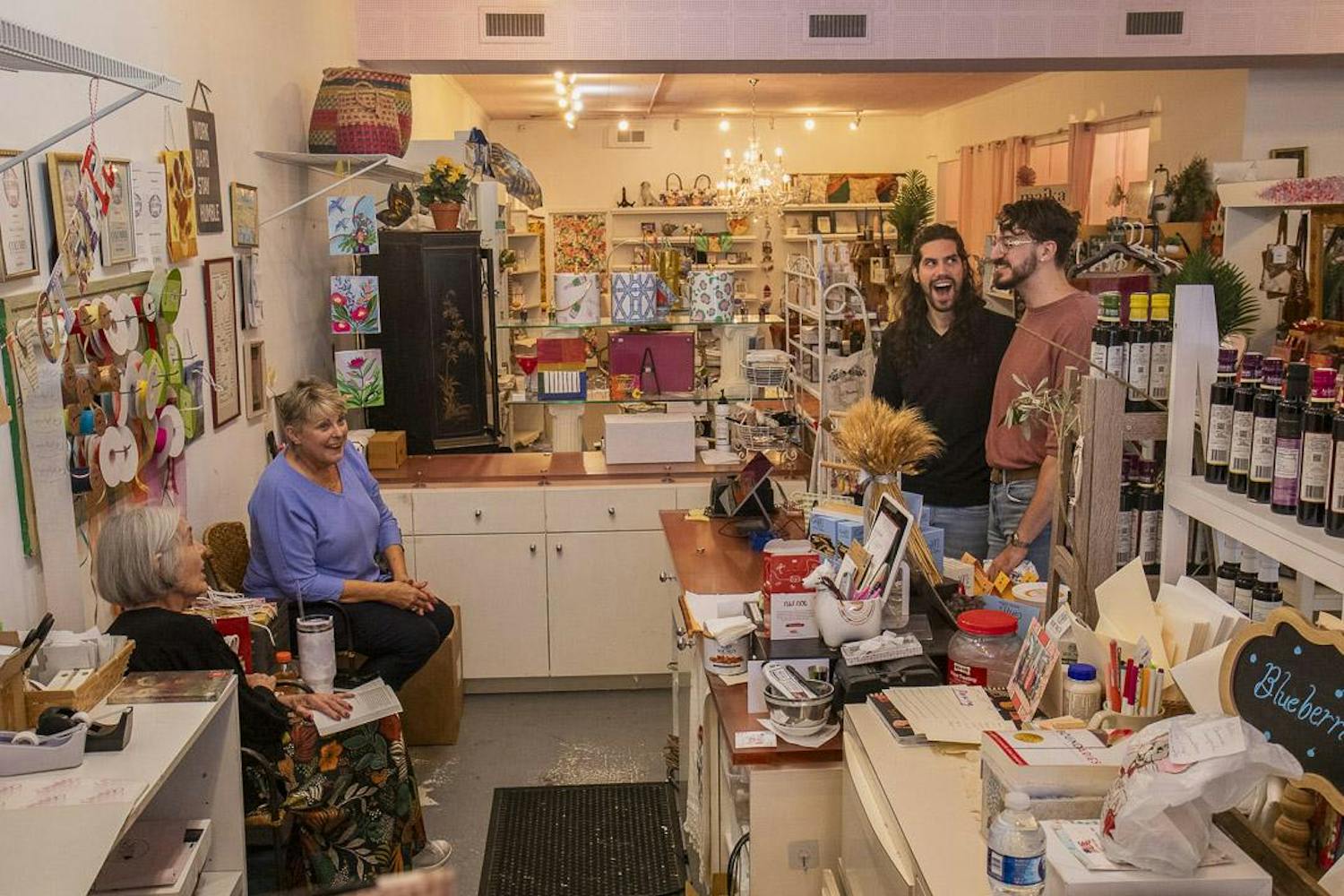 Gibson’s Gifts employees Mary Hanh (left) and Geneva Mobley (second to left) joke with Micah Peroulis (second to right) and William Miller (right) on Oct. 12, 2023. The store, known for its mix of stationery, crafts and handmade gifts, will rebrand to La Boheme in early 2024 to appeal to Five Points' younger demographic.