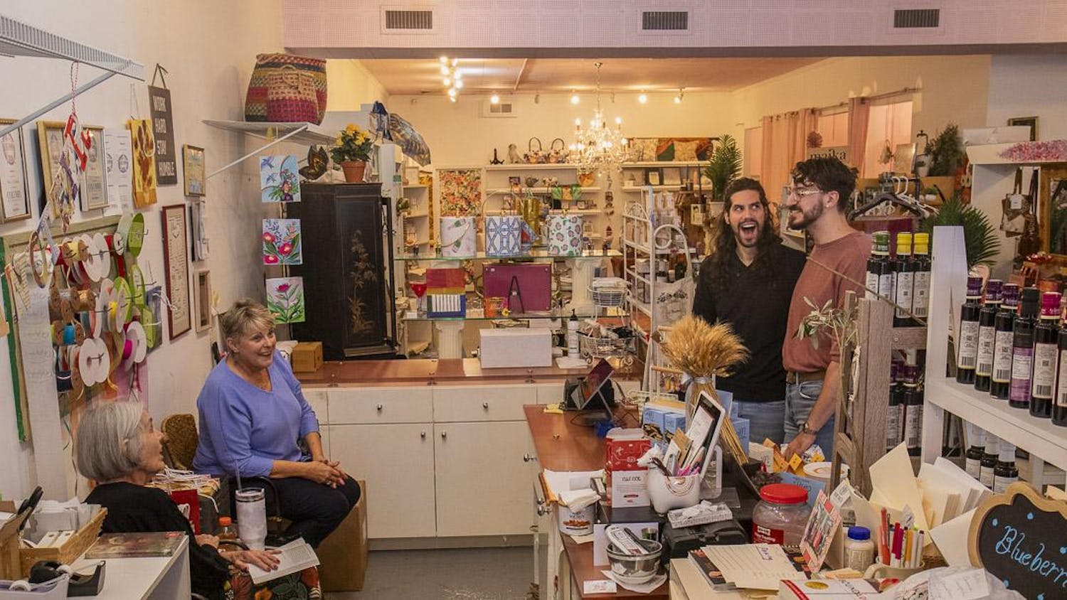 Gibson’s Gifts employees Mary Hanh (left) and Geneva Mobley (second to left) joke with Micah Peroulis (second to right) and William Miller (right) on Oct. 12, 2023. The store, known for its mix of stationery, crafts and handmade gifts, will rebrand to La Boheme in early 2024 to appeal to Five Points' younger demographic.