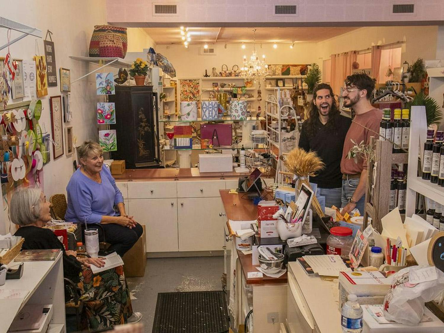 Gibson’s Gifts employees Mary Hanh (left) and Geneva Mobley (second to left) joke with Micah Peroulis (second to right) and William Miller (right) on Oct. 12, 2023. The store, known for its mix of stationery, crafts and handmade gifts, will rebrand to La Boheme in early 2024 to appeal to Five Points' younger demographic.