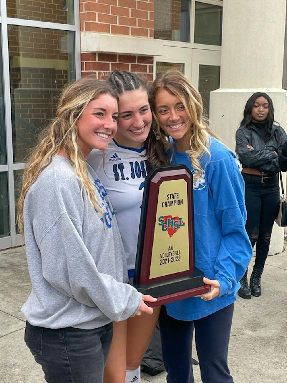 <p>Freshman setter Kimmie Thompson (center) poses with her sisters Kyra Thompson (on left) and Kaely Thompson (on right) after winning the State Championships for St. Joseph's Catholic School. Thompson earned four 2A state titles and helped the team win the state championship in her senior year of high school.</p>