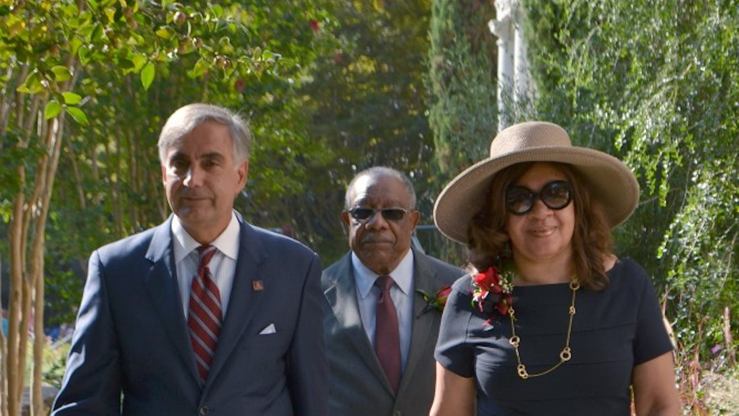 	University President Harris Pastides walks with Henrie Monteith Treadwell and James Solomon Jr. to the site of the future desegregation reflection garden.