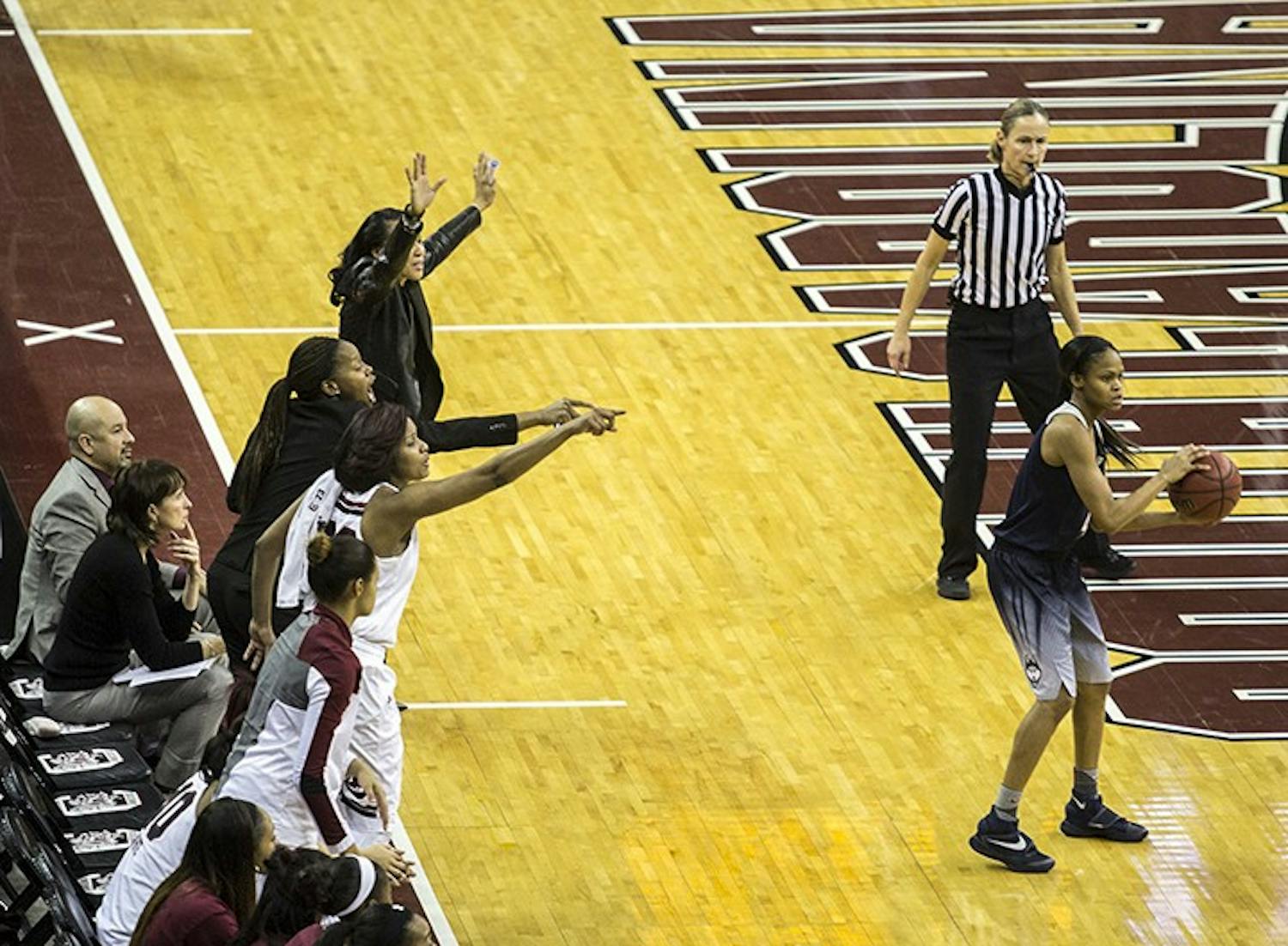 Dawn Staley, coaching staff, and Tina Roy all try to call attention to an ungaurded UConn player. 