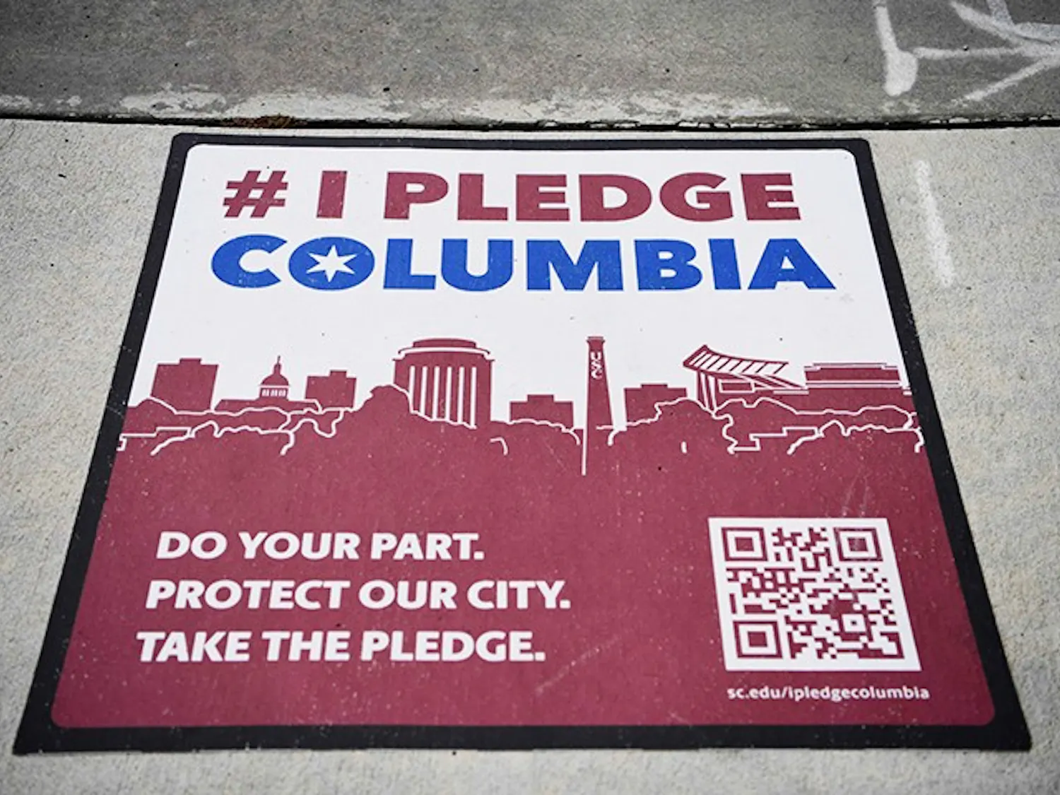 One of the many signs for #IPledgeColumbia sits on a sidewalk near campus.
