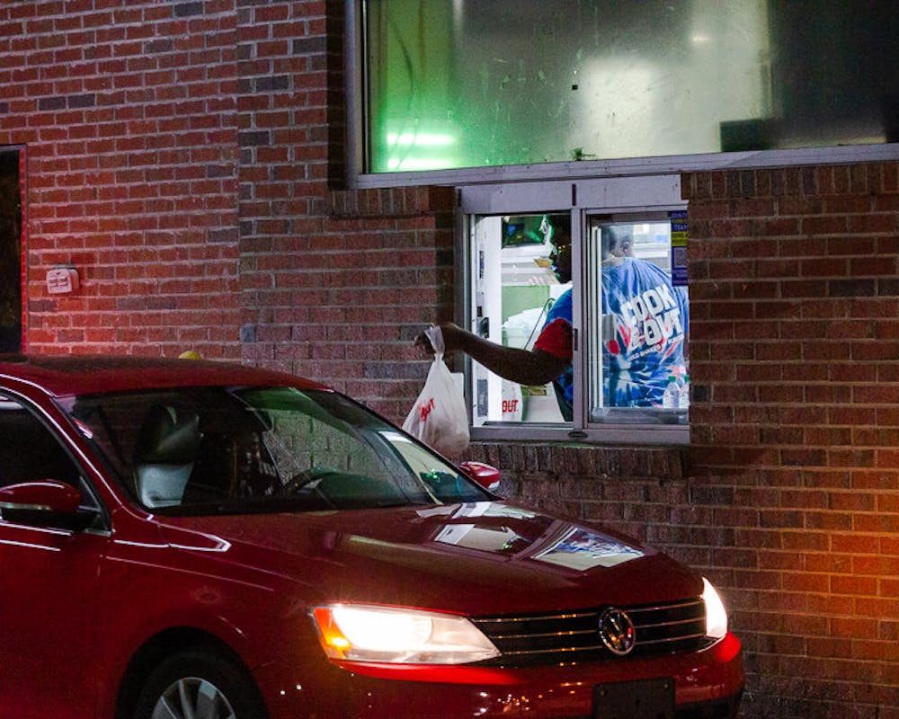 <p>A Cookout employee hands a customer their meal in the drive-thru at the Five Points location on Sept. 22, 2022. The Cookout near 鶹С򽴫ý's campus is open until 4 a.m. on weekdays and 5 a.m. on the weekends.</p>