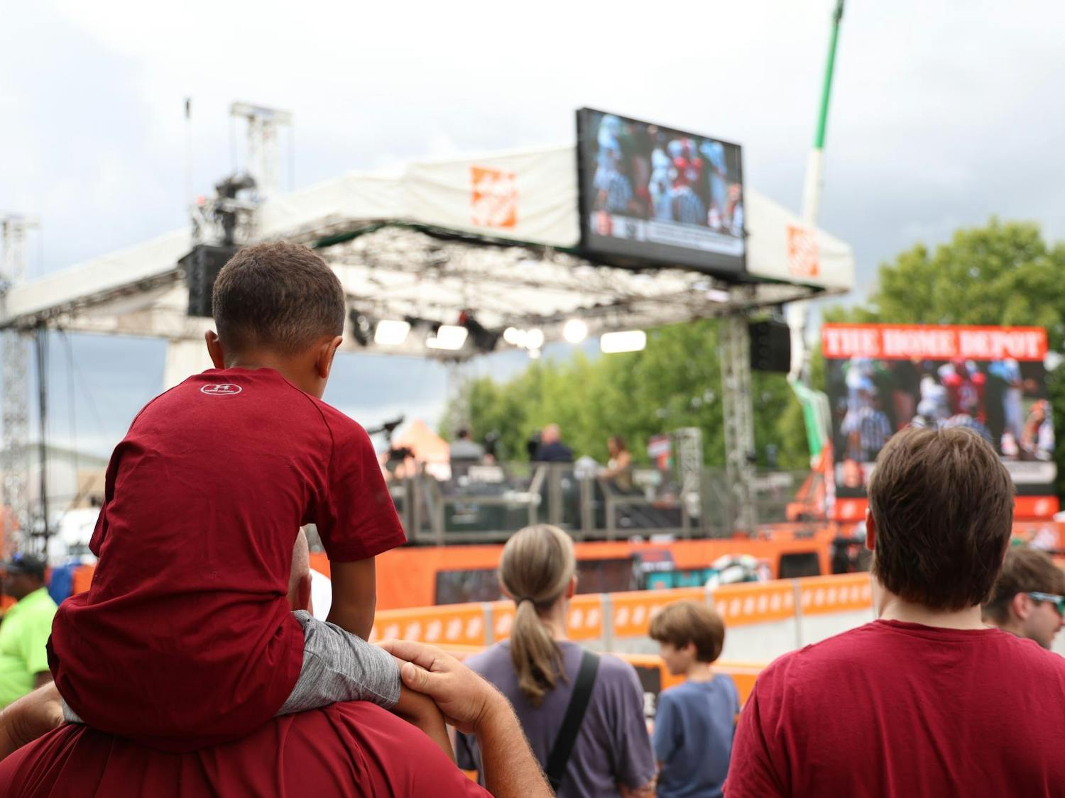 A young Gamecock fan sits on a man's shoulders to watch the set build of ESPN College GameDay on Sept. 13, 2024. The Gamecock fans eagerly await the early morning expected to come for the live showing of ESPN College GameDay.