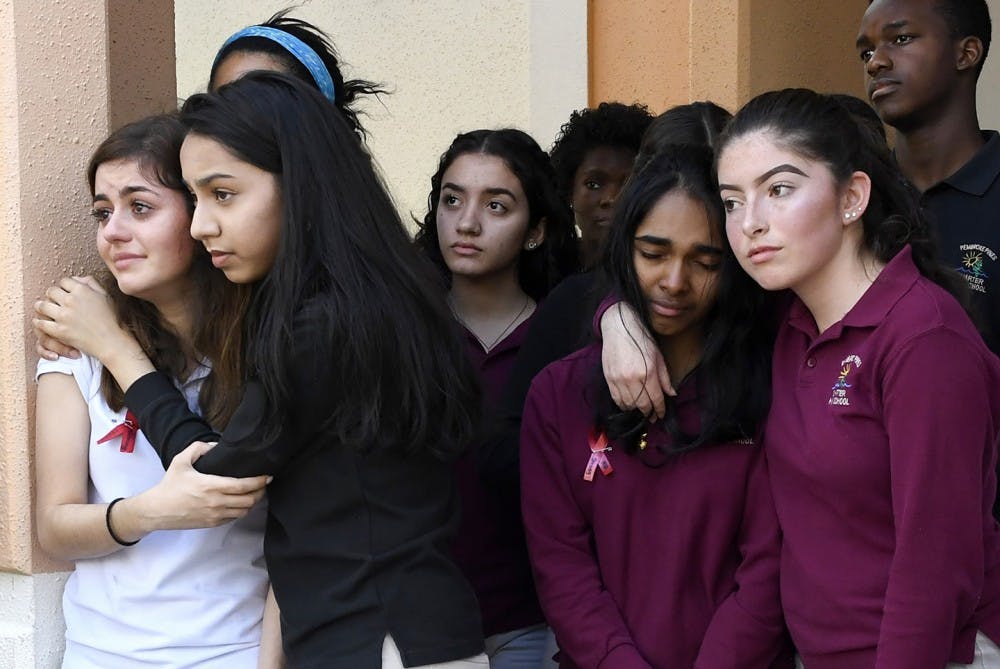 Pembroke Pines Charter High School students, from left, Brianna Adan, Naveen Farook, Swati Cumar, Sofia Mendoza and others listen to the names of the 17 killed during the mass shooting at Marjory Stoneman Douglas High School a week ago during the school&apos;s walkout Wednesday, Feb. 21, 2018, in Pembroke Pines, Fla. (Taimy Alvarez/Sun Sentinel/TNS) 