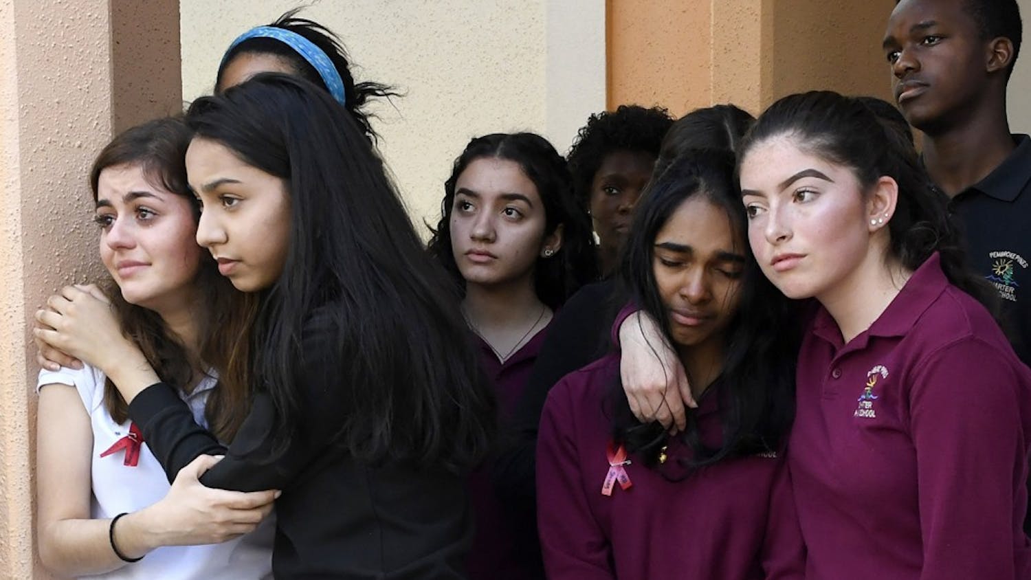Pembroke Pines Charter High School students, from left, Brianna Adan, Naveen Farook, Swati Cumar, Sofia Mendoza and others listen to the names of the 17 killed during the mass shooting at Marjory Stoneman Douglas High School a week ago during the school&apos;s walkout Wednesday, Feb. 21, 2018, in Pembroke Pines, Fla. (Taimy Alvarez/Sun Sentinel/TNS) 