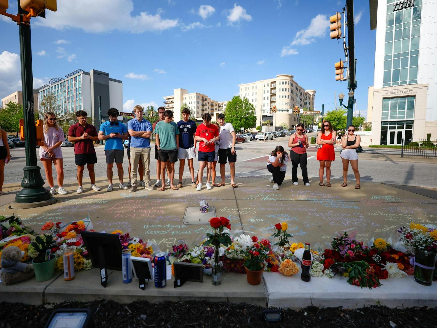 Students gather around a memorial in honor of Nathaniel "Nate" Baker on April 3, 2025. Friends, students and Columbia residents all came to leave flowers and other memorabilia in Baker's memory.