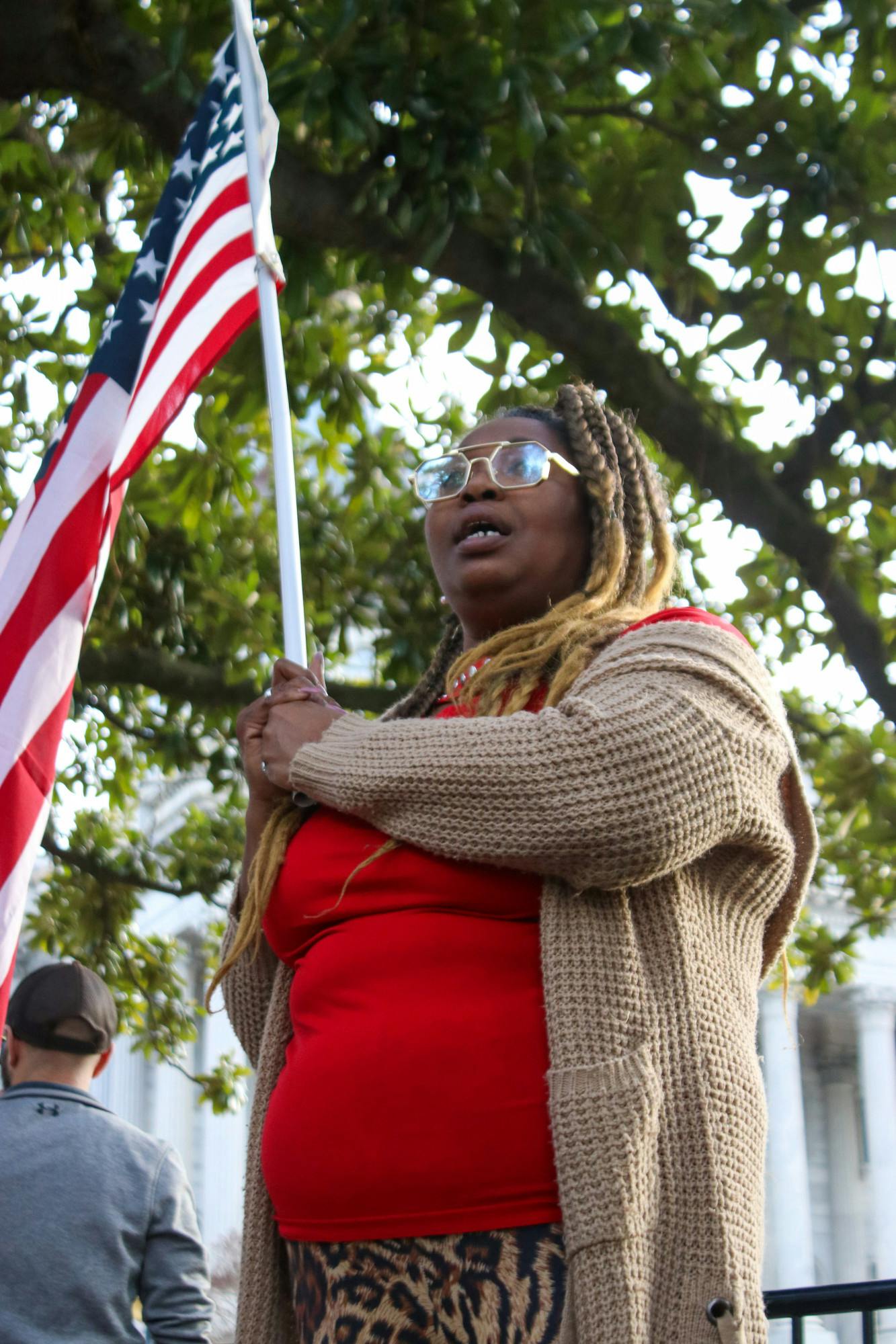 Virgina Mills holds an American flag while standing outside of the Statehouse on Jan. 28, 2023. Mills aligned herself with the Democratic party for about 30 years, before shifting ideologies. She said the Democratic Party weaponizes minority groups and overly generalizes them as struggling.&nbsp;
