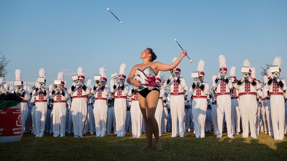 	Fourth-year broadcast journalism student Catherine Ramirez tosses her batons at a Parents Weekend tailgate. She will perform for the last time Saturday at the USC vs. Clemson game.
