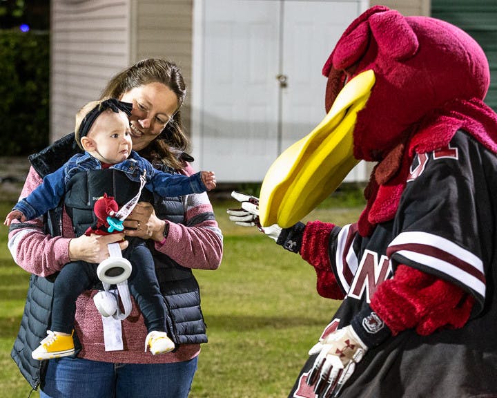 Twyla Wafford Stowe, a 2005 USC graduate and former Cocky mascot introduces her seven-and-a-half-year-old daughter, Sarah Jo Stowe to Cocky after the USC Tiger Burning ceremony on Nov. 21, 2022. USC hosts this event annually during the week leading up to the South Carolina-Clemson football rival match the following Saturday. This year Clemson is hosting the game at their field, "Death Valley" on Nov. 26, 2022.