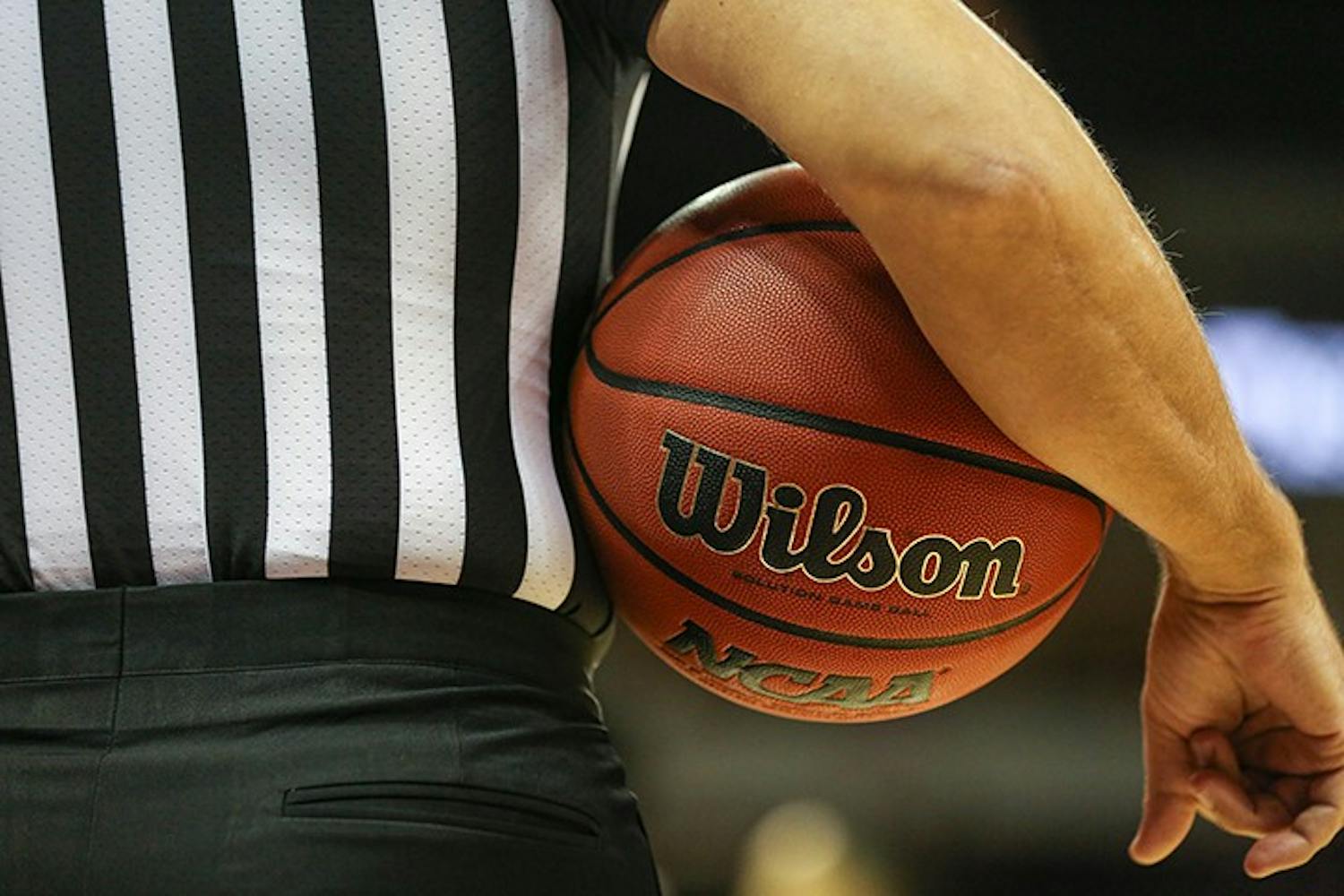 FILE— A referee holds a basketball under his arm during a timeout in a 2019 game at Colonial Life Arena in Columbia, SC.