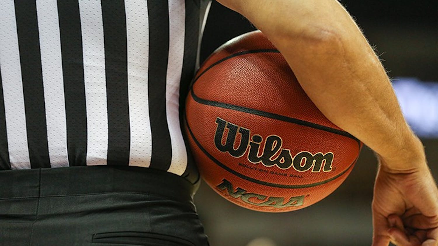 FILE— A referee holds a basketball under his arm during a timeout in a 2019 game at Colonial Life Arena in Columbia, SC.
