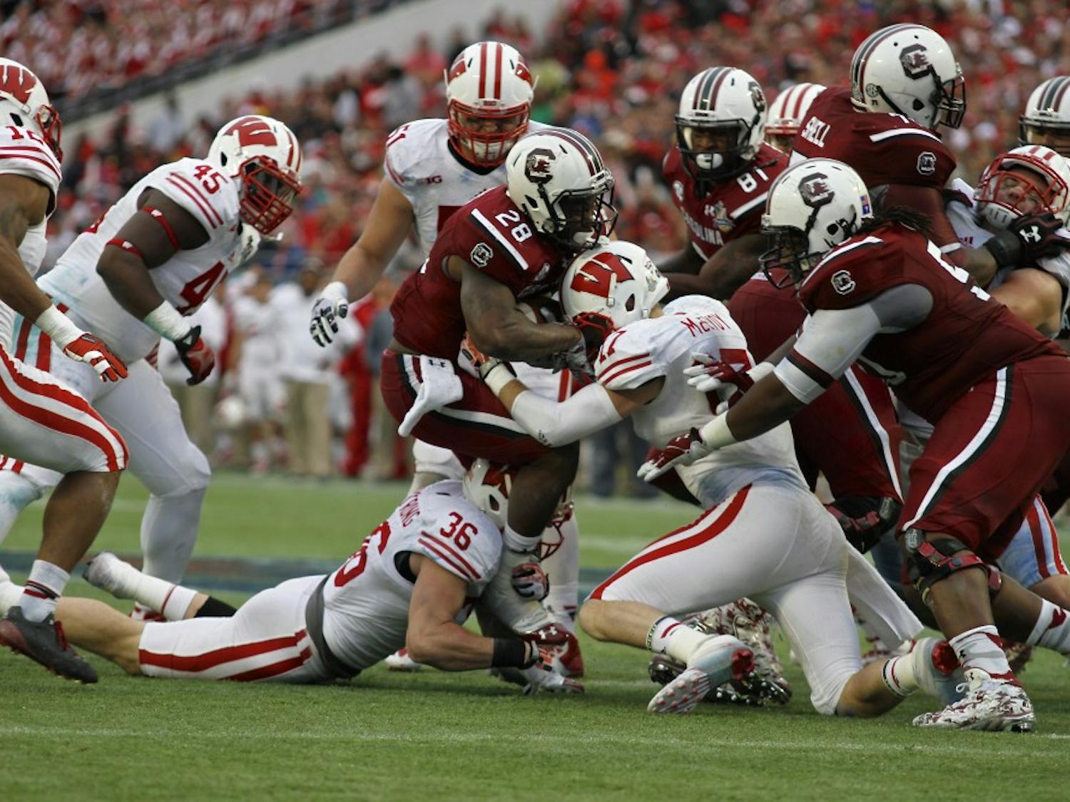 	Running back Mike Davis is tackled by Wisconsin defenders at the Capital One Bowl on Jan. 1. He ran nine times for 49 yards in the 34-24 win.