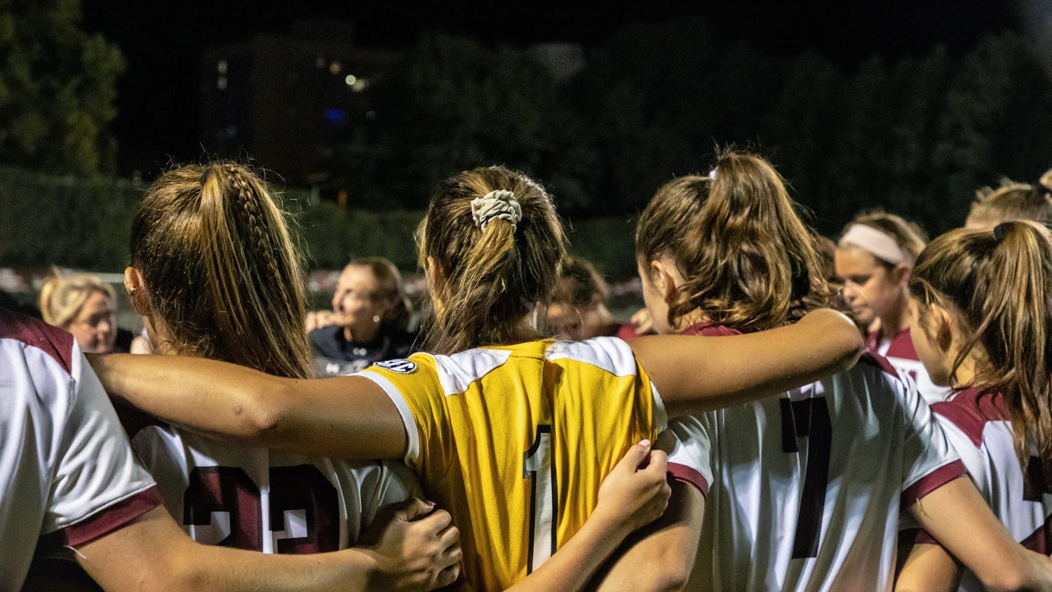 The women's soccer team in a huddle during a time-out during a game against the Georgia Bulldogs. 