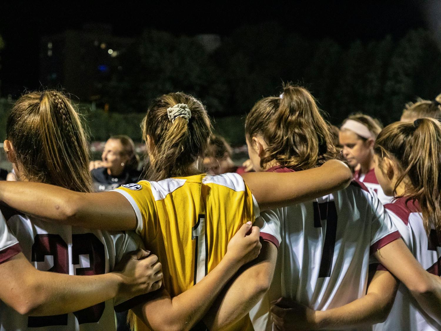 The women's soccer team in a huddle during a time-out during a game against the Georgia Bulldogs. 