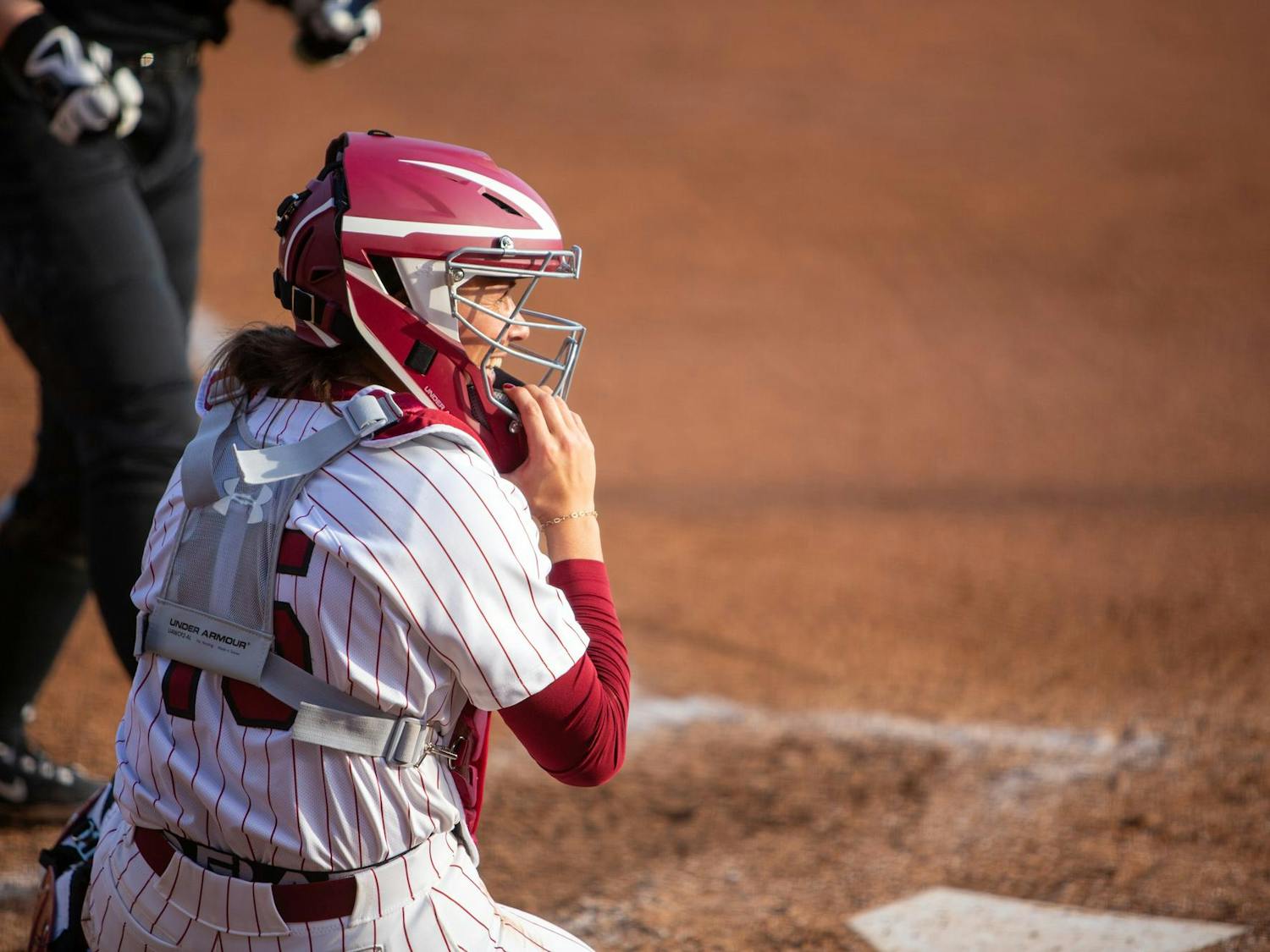Junior catcher Lexi Winters smiles as she prepares for the inning behind the plate on Feb. 9, 2025. The Gamecocks defeated the Friars 8-0 in five innings.
