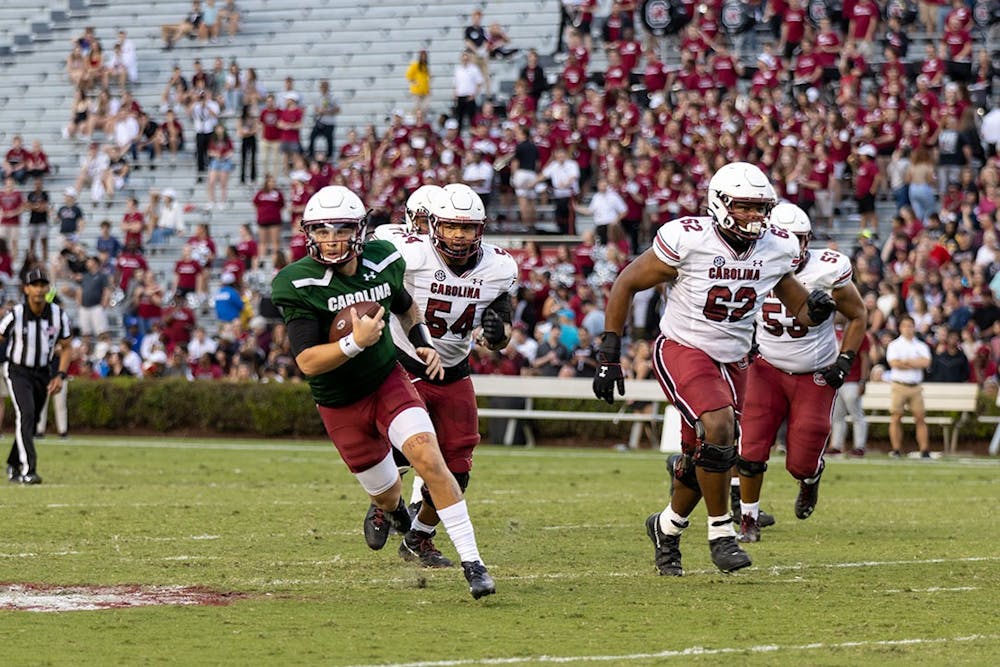 Redshirt junior quarterback Spencer Rattler traveling down the field with the ball after evading a tackle, gaining yards for the Garnet team. The Garnet team won 20-13 at Williams-Brice Stadium on April 17, 2022.