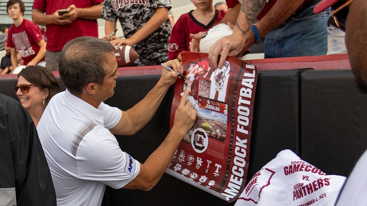 FILE— South Carolina football head coach Shane Beamer signing a football poster before taking on Eastern Illinois on Sept. 4, 2021.