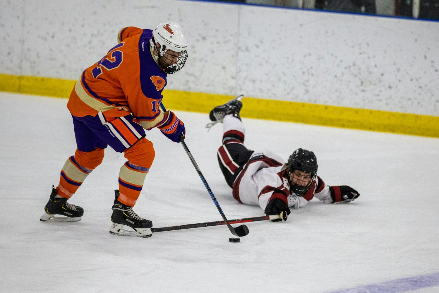 Sophomore winger Tommy Lokken slides across the ground in an attempt to recover the puck following a Clemson breakaway during a match on Nov. 11, 2022. The game's first period kicked off with a series of aggressive advances as players from both teams slammed each other against boards and across the ice to capture early momentum.