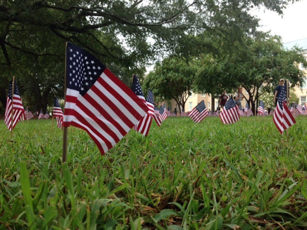<p>U.S. flags dotted Davis Field outside of Russell House on Friday, each flag representing one innocent victim killed in the September 11th attacks.</p>
