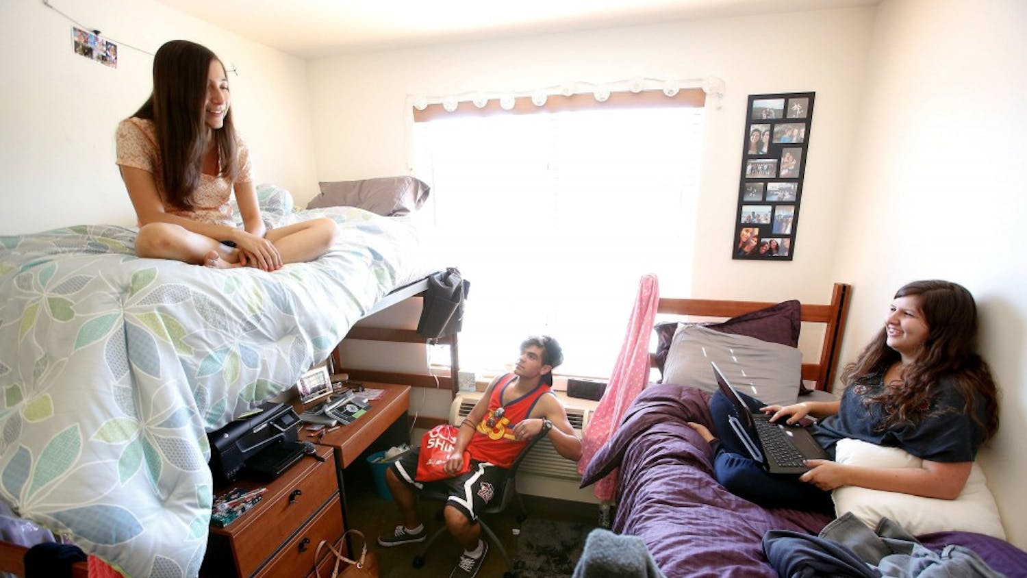 Shelby Ryan, 18, left, from Sherman Oaks, a freshman at Cal State Northridge, and her roommate Abby Souza, 18, right, from Davis, hang out inside their dorm room with Austin Garcia, 18, from Bakersfield, who was visiting from his room located down the hall of the coed dorm, August 26, 2013. All three students are freshmen. (Mel Melcon/Los Angeles Times/MCT)