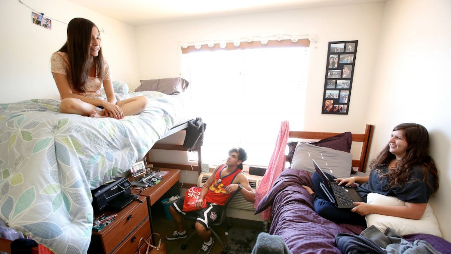 Shelby Ryan, 18, left, from Sherman Oaks, a freshman at Cal State Northridge, and her roommate Abby Souza, 18, right, from Davis, hang out inside their dorm room with Austin Garcia, 18, from Bakersfield, who was visiting from his room located down the hall of the coed dorm, August 26, 2013.  All three students are freshmen. (Mel Melcon/Los Angeles Times/MCT)