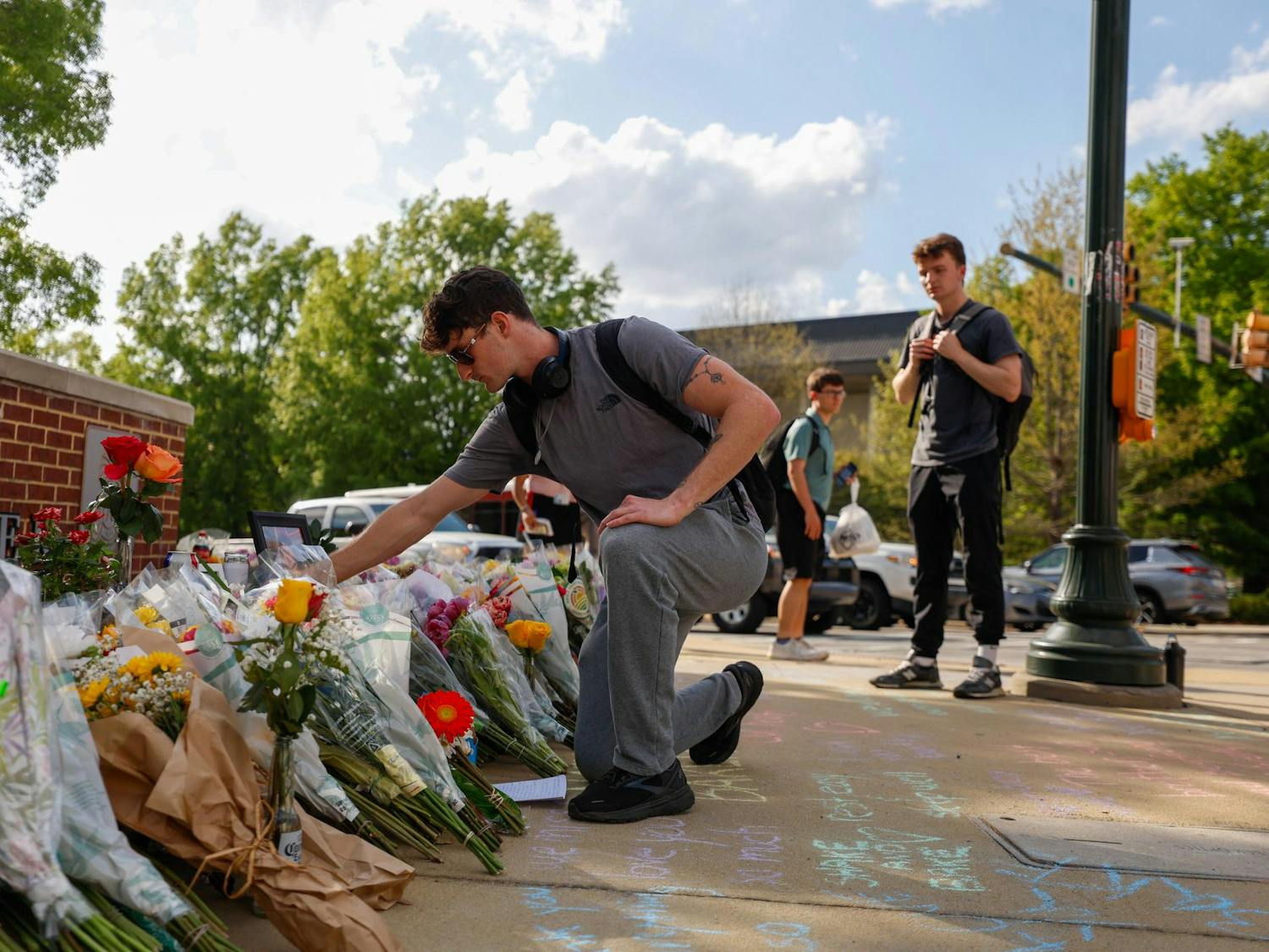 A student places a cross at the memorial for Nathaniel "Nate" Baker outside Strom Thurmond Wellness and Fitness Center on April 3, 2025. The previous day, Baker was the victim of a hit-and-run while riding his motorcycle at the intersection of Assembly and Blossom streets.