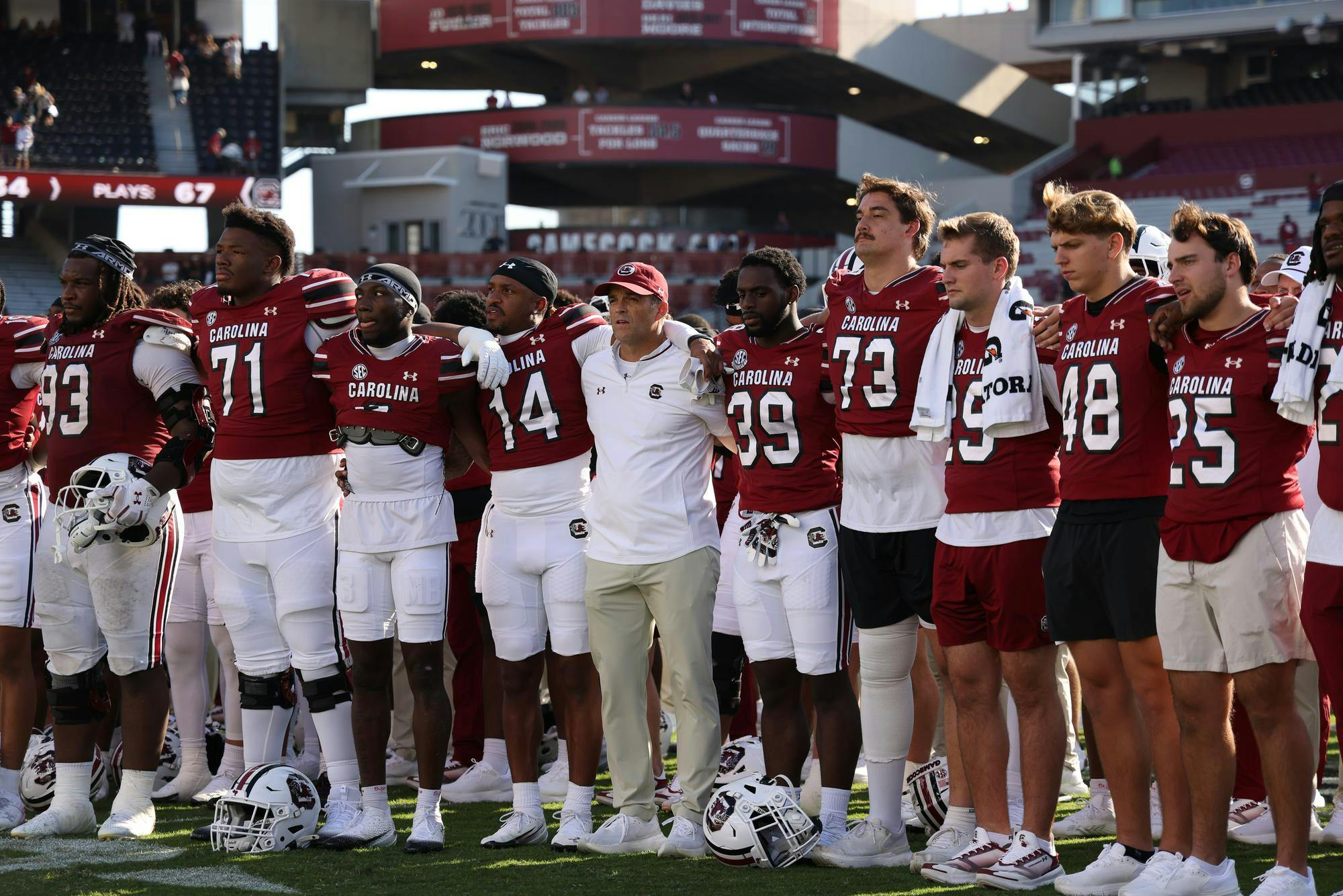 The South Carolina football team sings the University of South Carolina alma matar with their arms around each other.