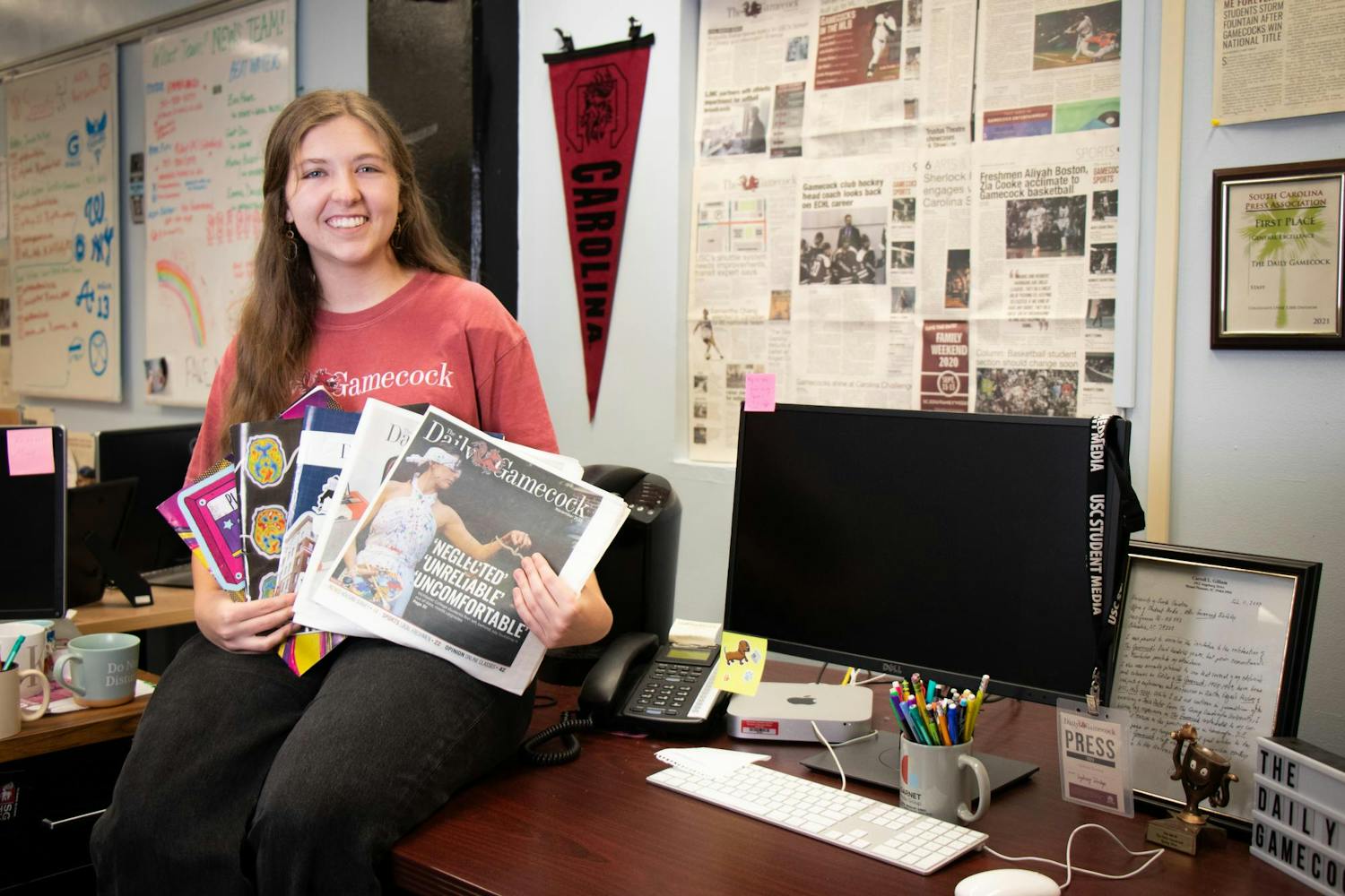 The Editor-in-Chief of The Daily Gamecock, Sydney Dunlap, poses on her desk on Dec. 3, 2023, holding each print edition she worked on as editor-in-chief. Dunlap held this position for the spring and fall 2023 semesters.