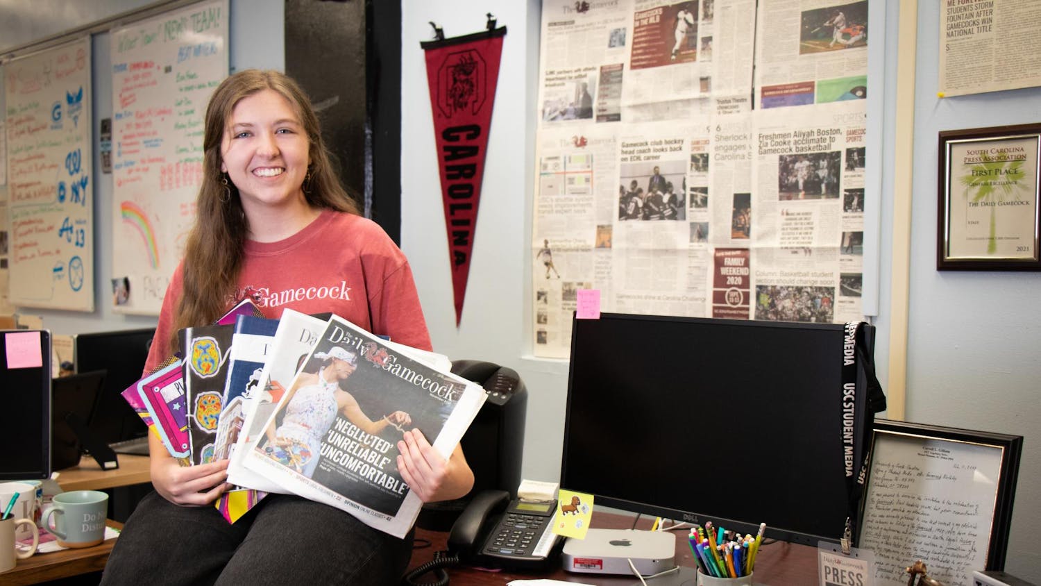 The Editor-in-Chief of The Daily Gamecock, Sydney Dunlap, poses on her desk on Dec. 3, 2023, holding each print edition she worked on as editor-in-chief. Dunlap held this position for the spring and fall 2023 semesters.