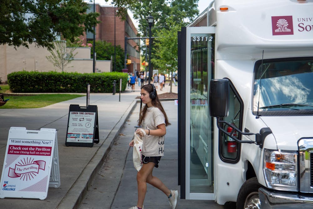 <p>FILE — A student walks off the lunchtime shuttle on Greene Street on Aug. 26, 2024. The shuttle, which runs from 11 p.m. to 2 p.m on weekdays, runs between Campus Village and Russell House.</p>