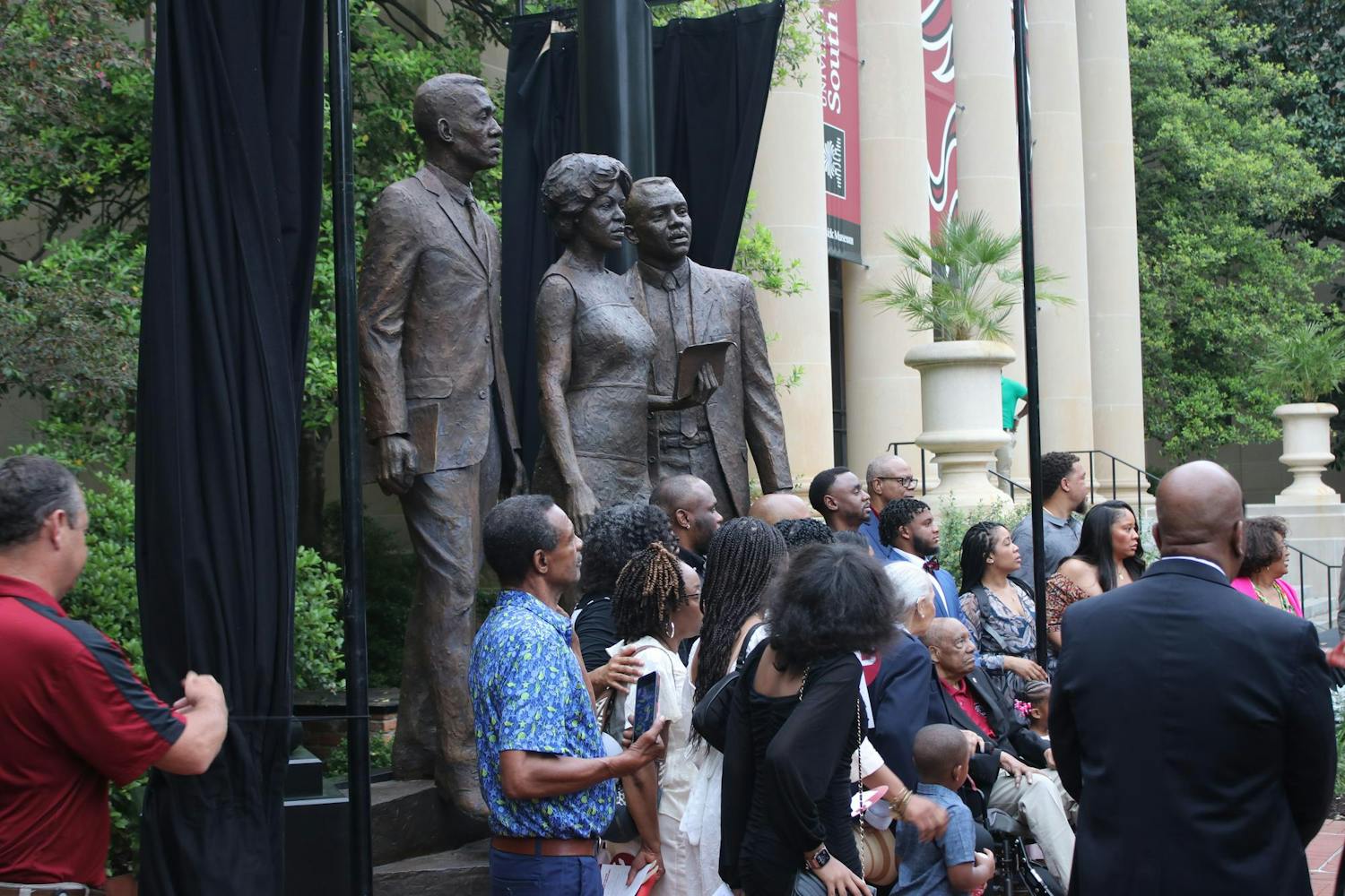 People gather to take a picture in front of the new desegregation monument on the University of South Carolina Horseshoe after its unveiling on April 19, 2024. The ceremony was attended by ɫɫƵs, university faculty, families of the honorees, the sculptor of the monument and the public.