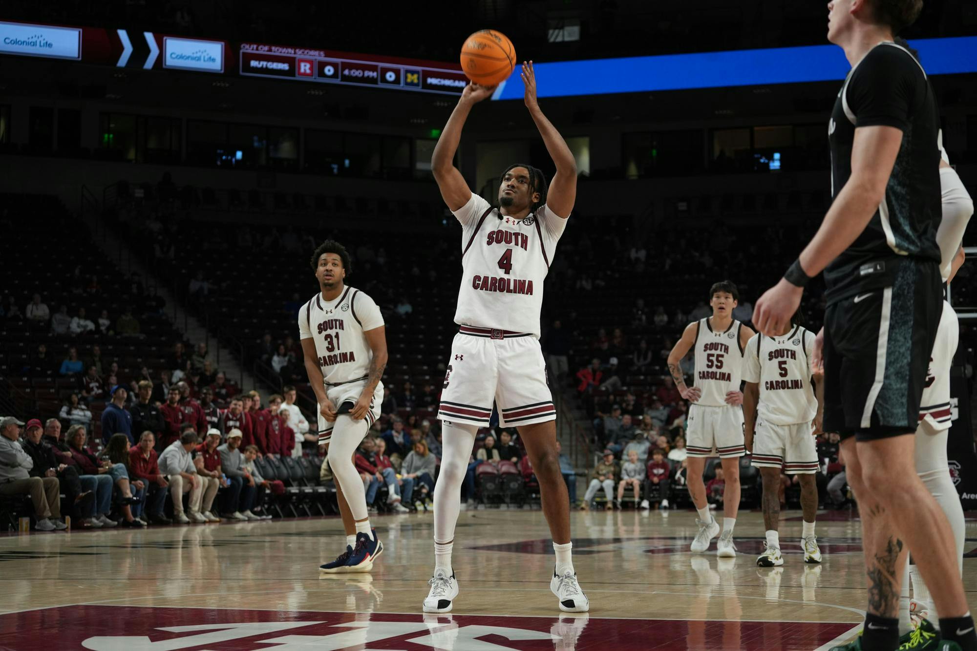 Redshirt senior guard Kobe Knox focuses at the line while teammates and opponents prepare for the rebound. The sequence took place at Colonial Life Arena in Columbia, South Carolina.