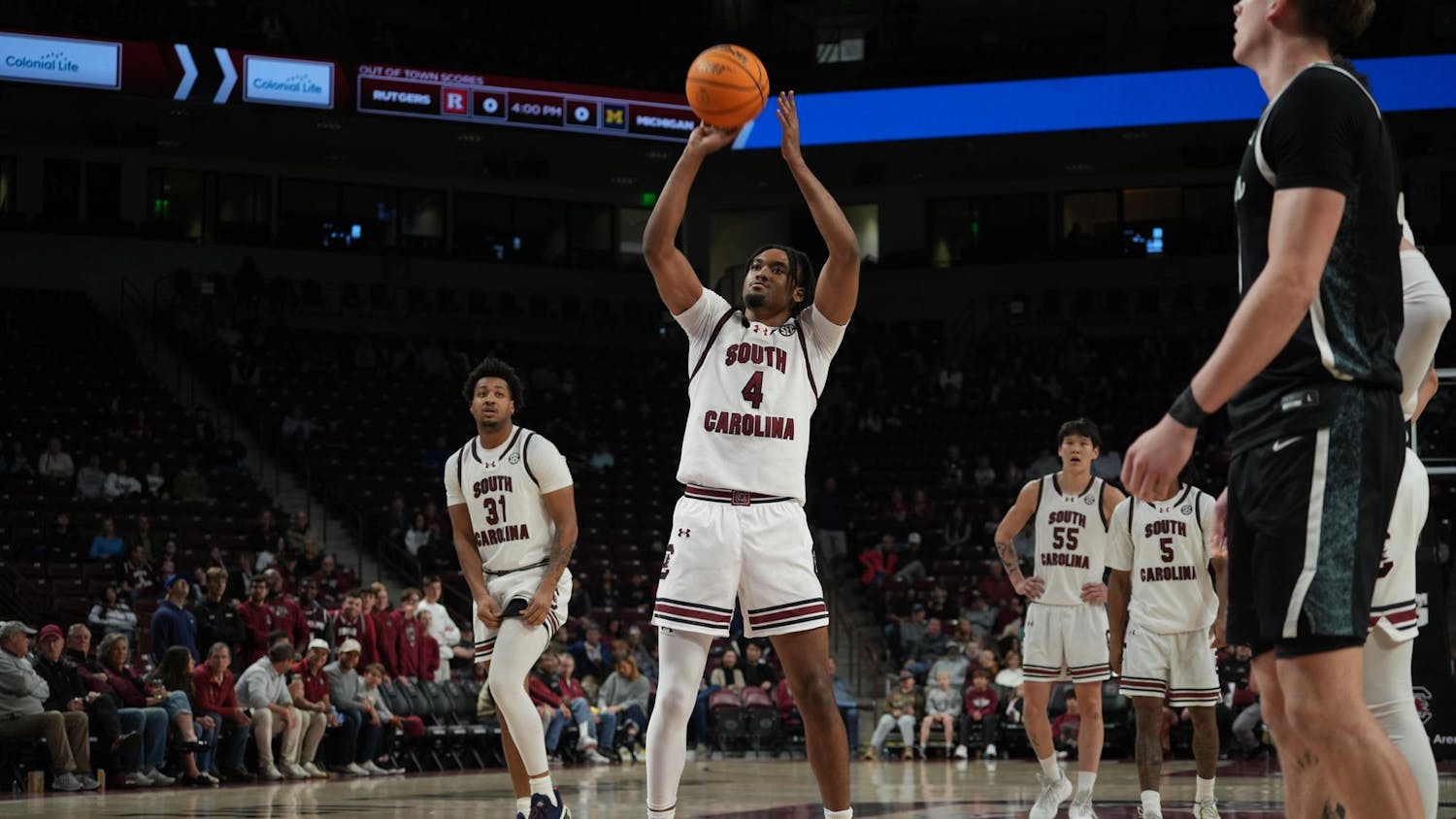 Redshirt senior guard Kobe Knox focuses at the line while teammates and opponents prepare for the rebound. The sequence took place at Colonial Life Arena in Columbia, South Carolina.