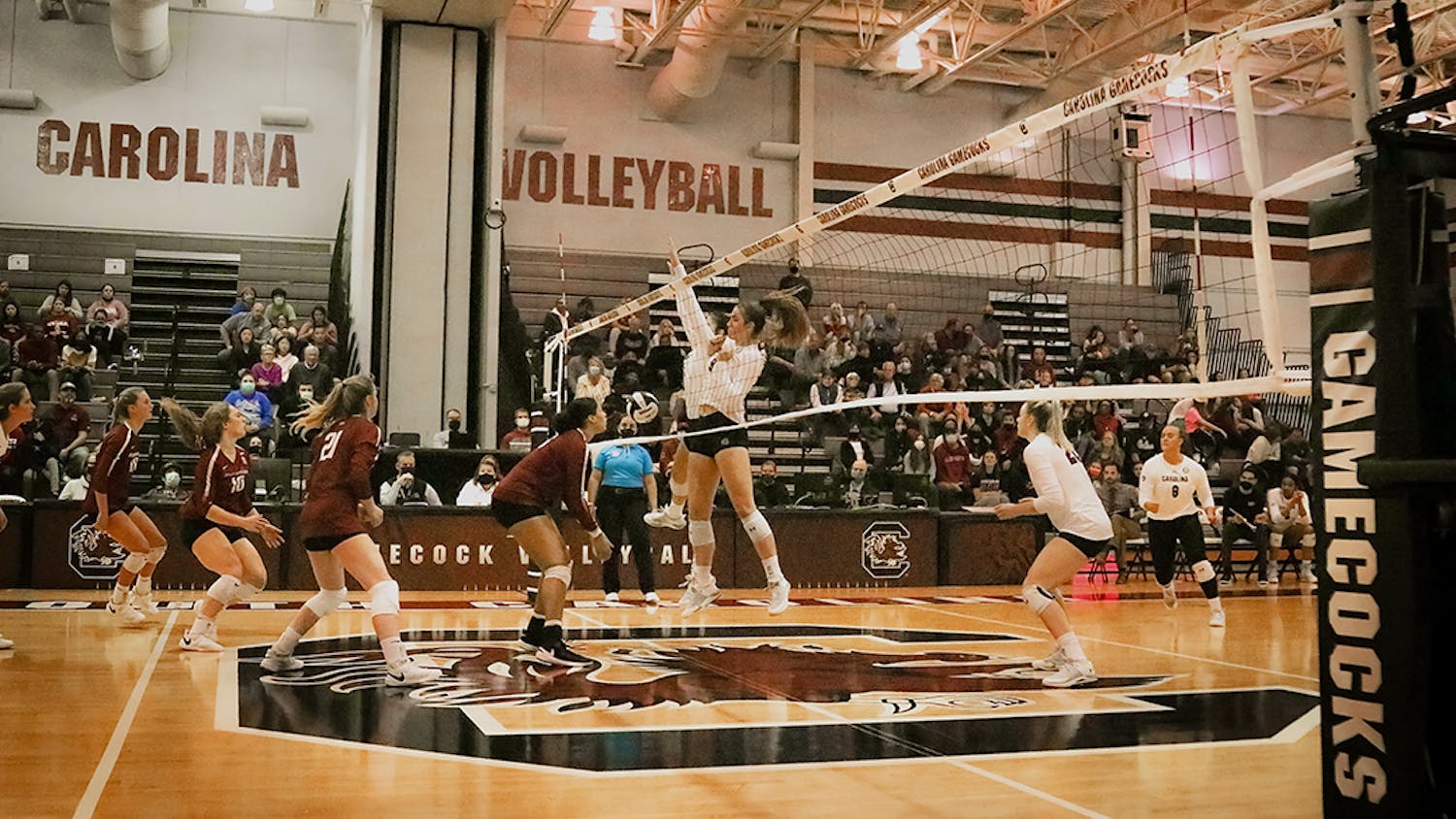 The players block a hit from the Arkansas Razorbacks and score. The Women’s Volleyball team goes on to lose to the Razorbacks in all 3 sets. 