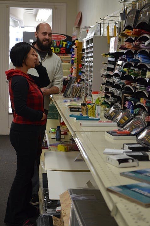 	S&amp;S Art Supply owner Eric Stockard helps a customer choose supplies. The store will close this month.