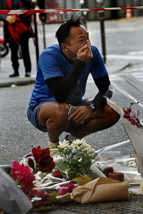 Parisians stop by the site of two cafe shootings, one at Cafe Bonne Biere, on Sunday, Nov. 15, 2015. (Carolyn Cole/Los Angeles Times/TNS)
