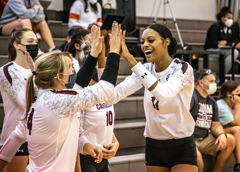 <p>Senior Lauren Bowers high-fives senior Mikayla Robinson after Robinson scores a point. The Gamecocks defeated the Winthrop Eagles in three straight sets. &nbsp;</p>