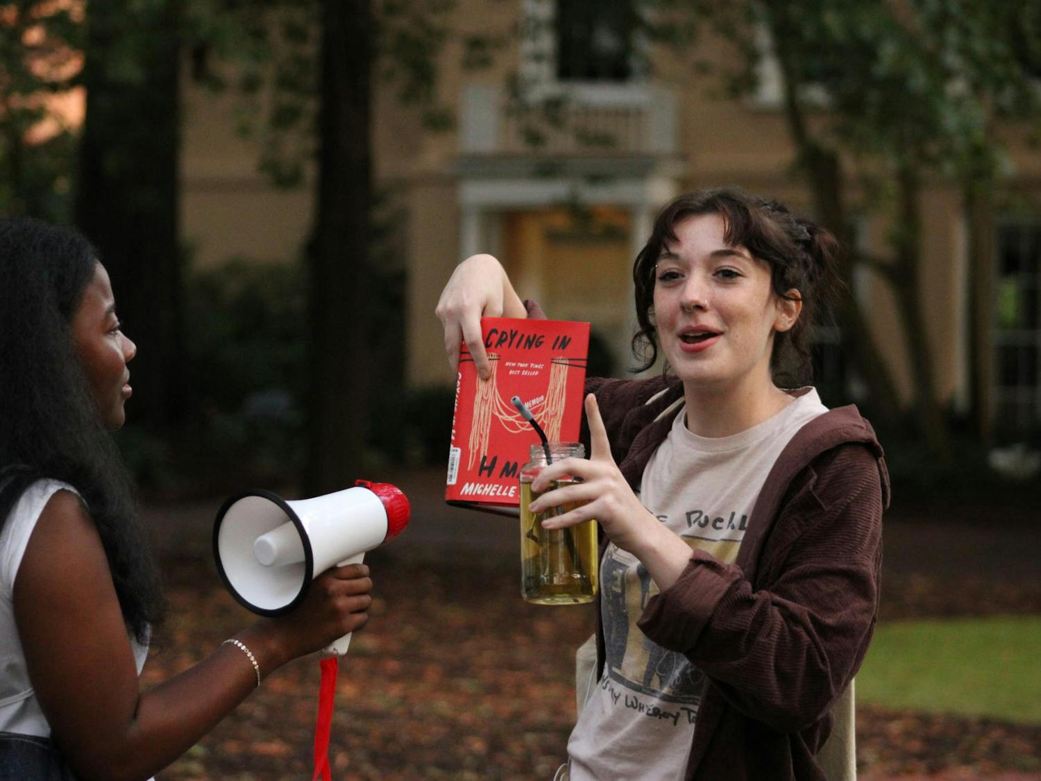 First-year art studio student Stella Drill, a competitor in the Performative Male Contest, discusses one of the books she brought. Students came to watch her and many others compete at the Horseshoe on Sept. 20, 2025.