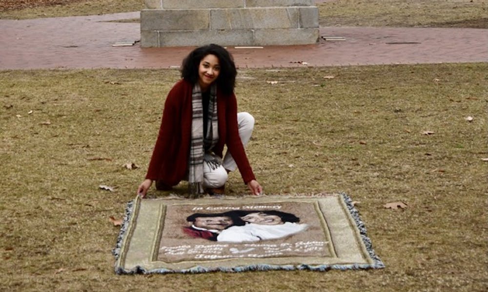 <p>&nbsp;Antonia Adams poses with a quilt that is in memory of her late parents.&nbsp;</p>