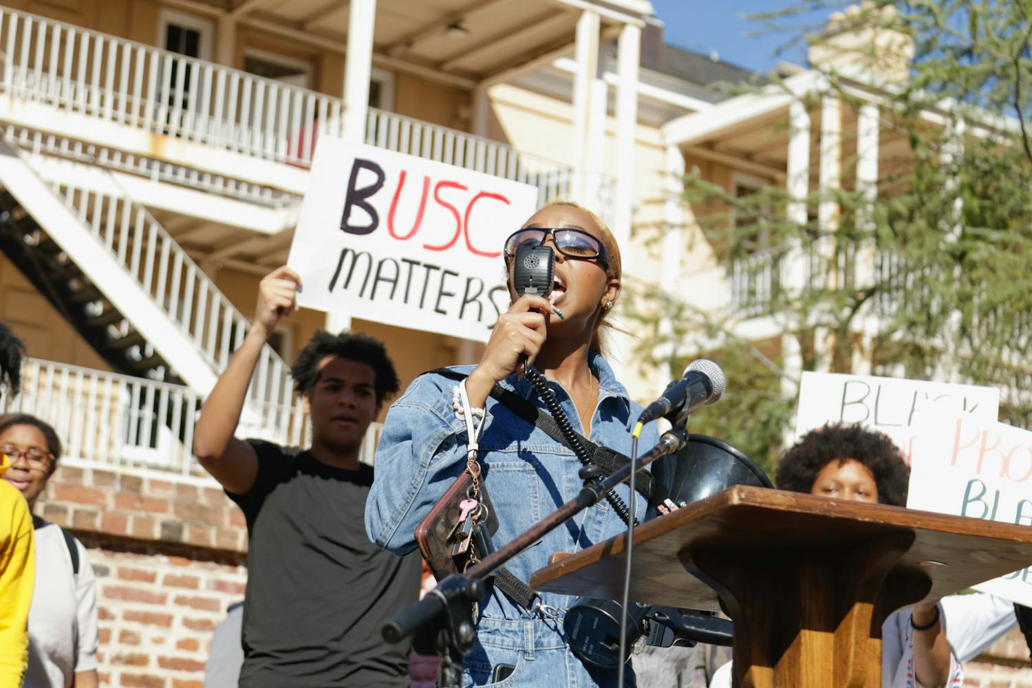 Fourth-year broadcast journalism student Courtney McClain speaks into a megaphone as the rest of the protesters make their way to the stage on Greene Street. The protest was organized by McClain, the president of the SC NAACP Y&amp;C Division.