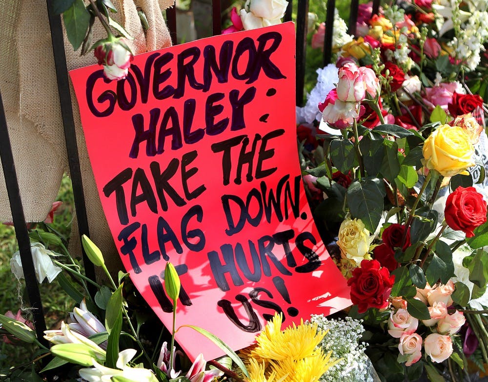 A sign urging South Carolina Gov. Nikki Haley to take down the confederate flag is part of the sidewalk memorial at the "Mother" Emanuel A.M.E. Church on Saturday, June 20, 2015, in Charleston, S.C. (Curtis Compton/Atlanta Journal-Constitution/TNS)