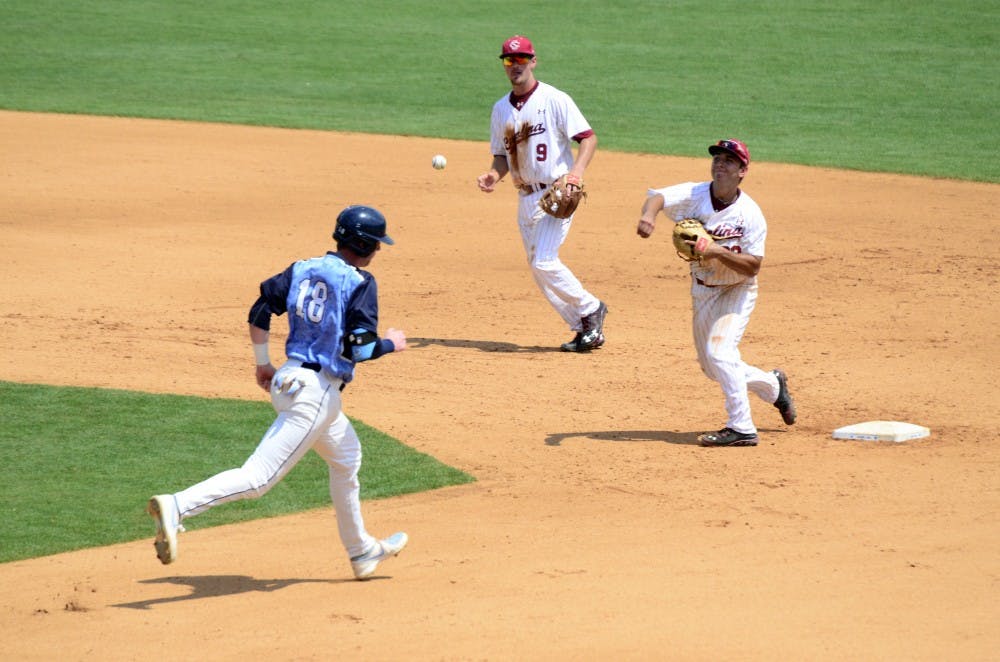 Gamecocks second baseman Max Schrock throws the ball to first for a double play.