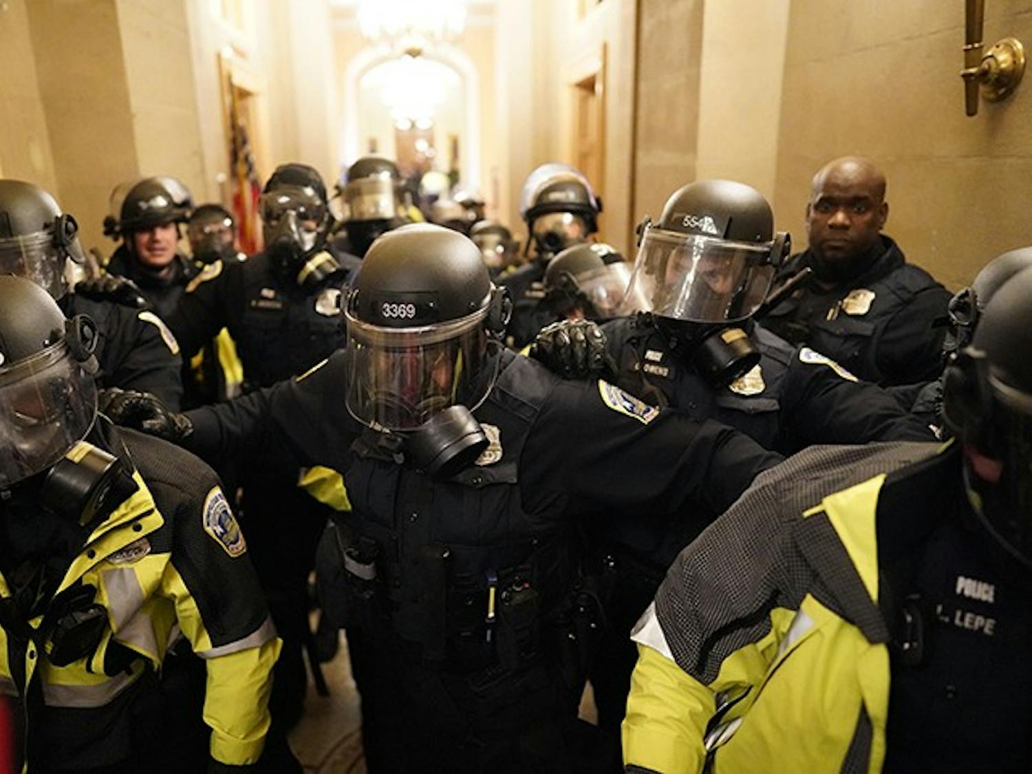 Riot police clear the hallway inside the Capitol on Wednesday, Jan. 6, 2021, in Washington, D.C.