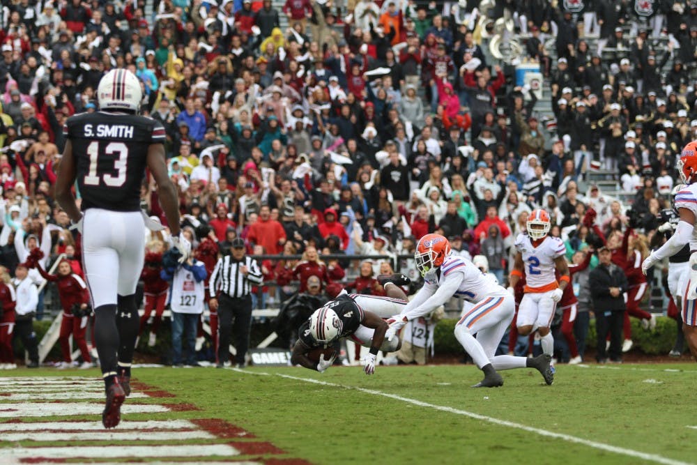 Senior running back Tavien Feaster dives forward for a touchdown during the game against Florida Saturday.