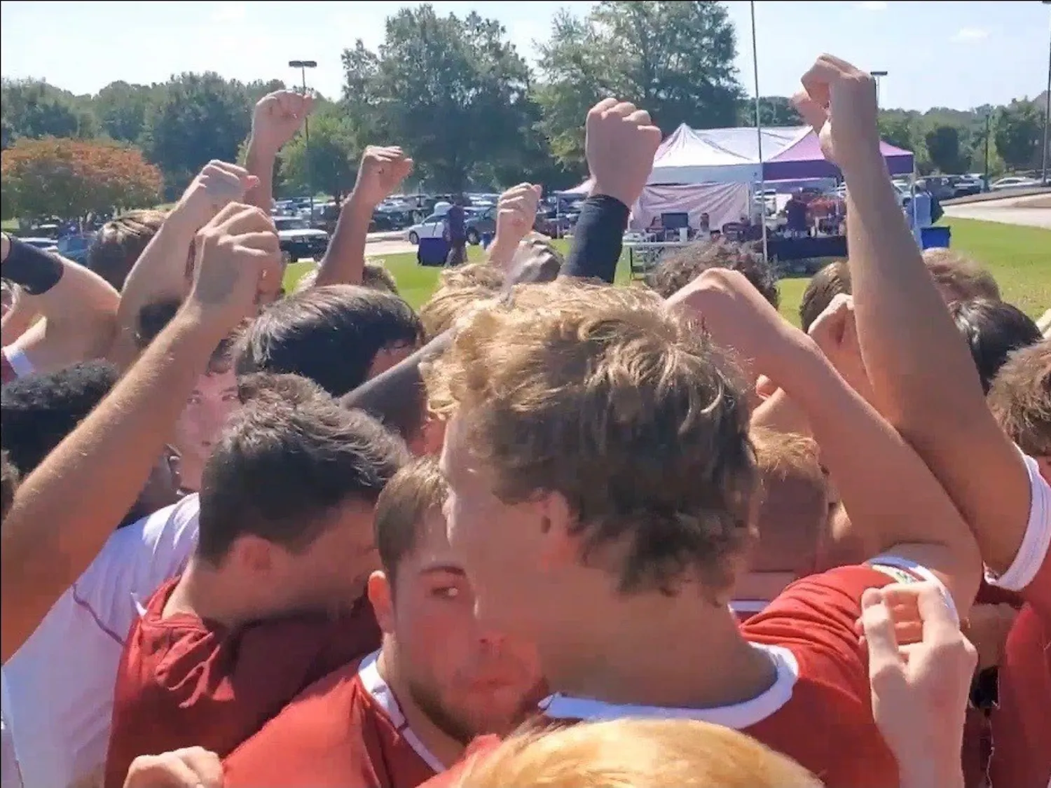 Members of the Gamecock club rugby team stand with their fists in the air.