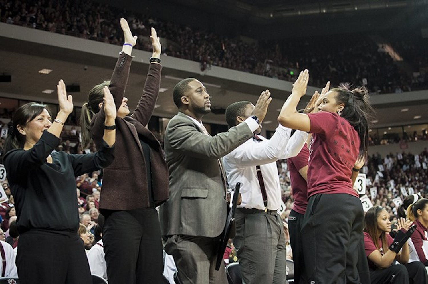 The women's basketball coaching staff celebrates after a 3 pointer is made by Tina Roy. The coaching staff help foster a family enviroment for the team on and off the court. 