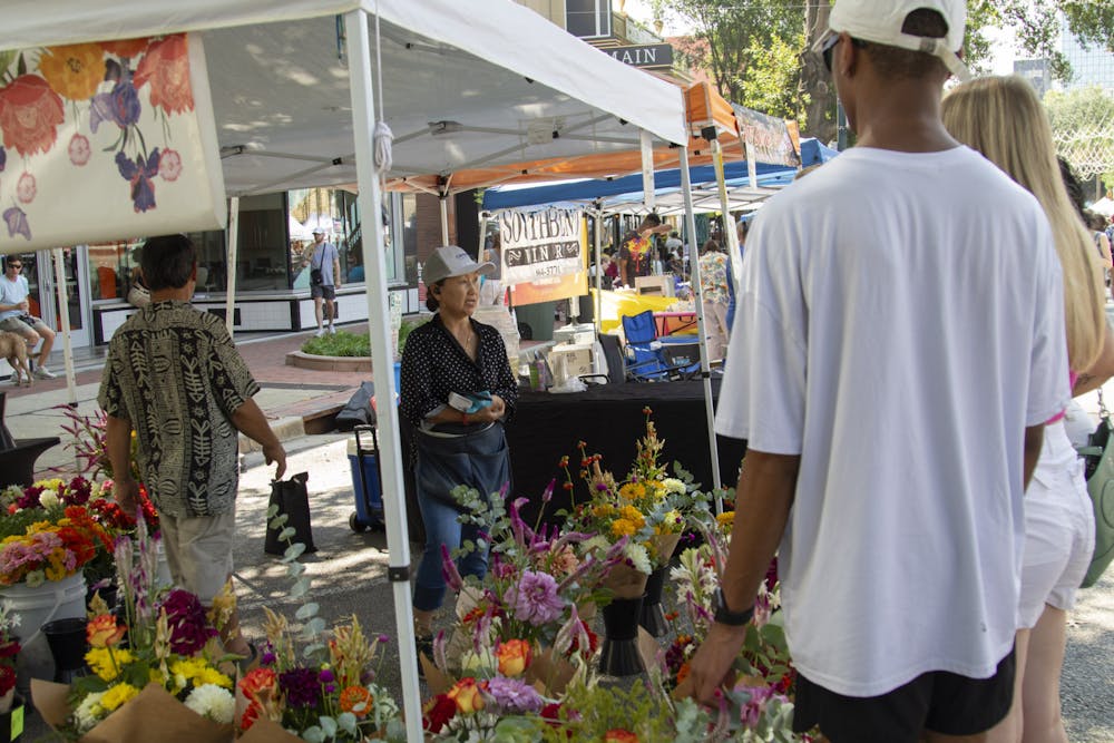 <p>FILE&nbsp;— Members of the Columbia community purchase flowers at Soda City Market on Aug. 26, 2023. Every Saturday, vendors line Main Street in Columbia, S.C., for a farmers and arts market.&nbsp;</p>